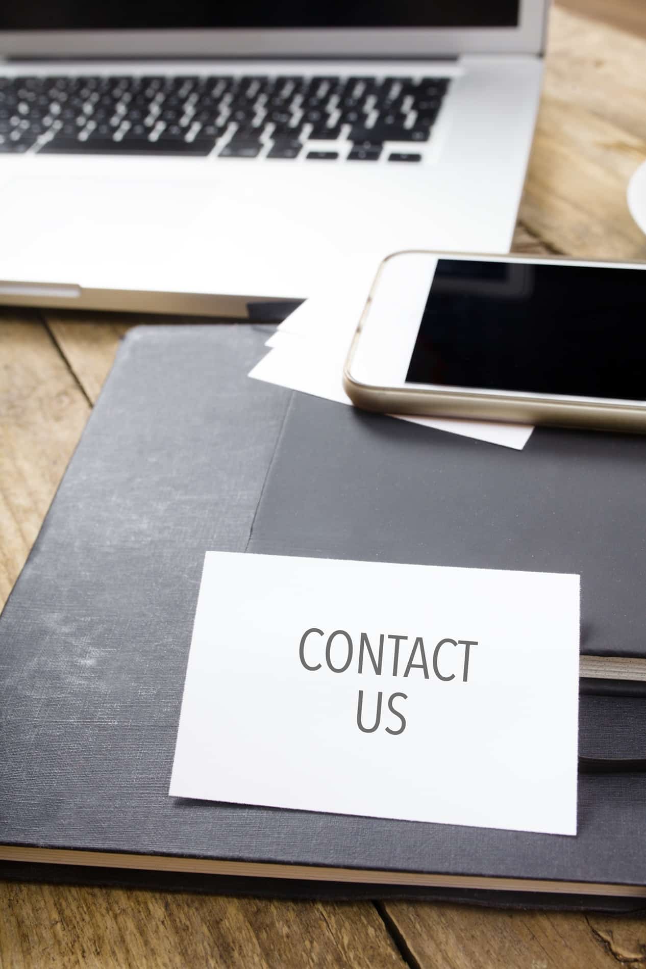 Card saying Contact Us on note pad
